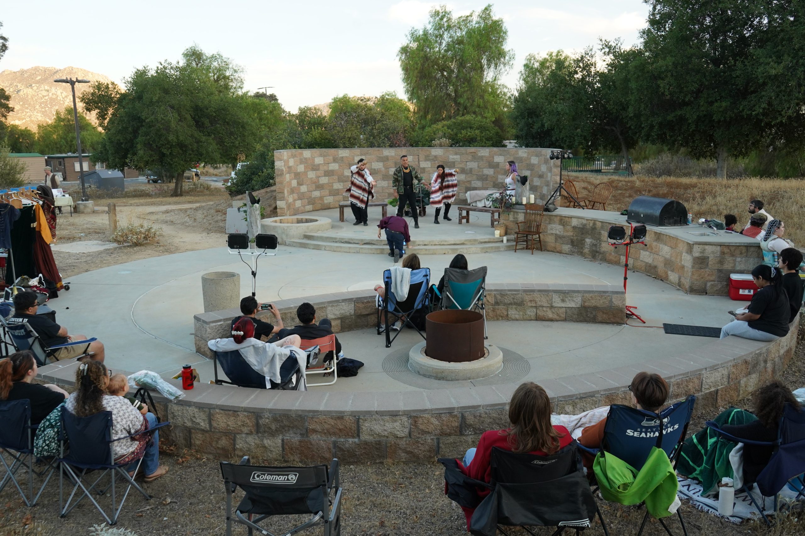 The cast of La Mujer Dormida take the stage at the Lake Perris SRA Campfire Center as campers and other visitors look on.